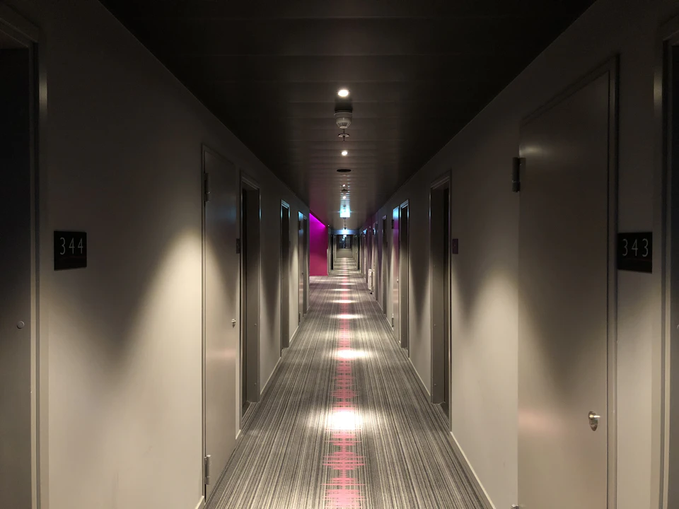 A softly lit hotel corridor lined with room doors